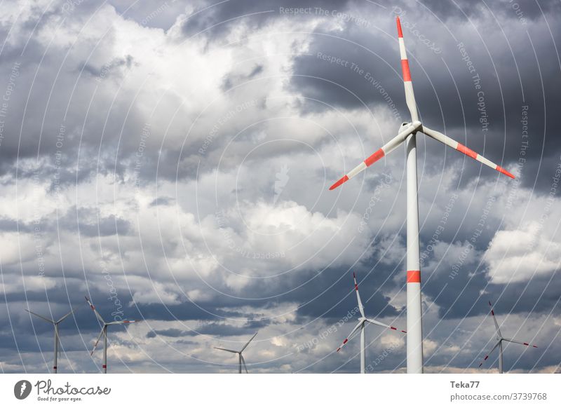 moderne Windräder vor bewölktem Sturmhimmel Windrad Windkraftanlage Windturbinen bewölkter Himmel Gewitterhimmel Wolken Gewitterwolken Ökostrom Windenergie