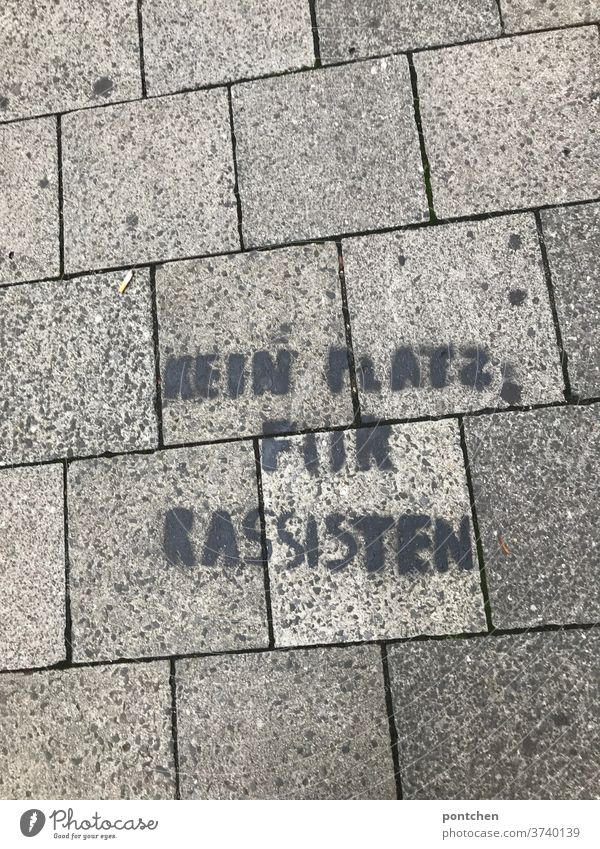 Kein Platz für rassisten steht auf Pflastersteinen am Boden. Botschaft, streetart. Antirassismus. Rassismus antirassismus botschaft widerstand politisch