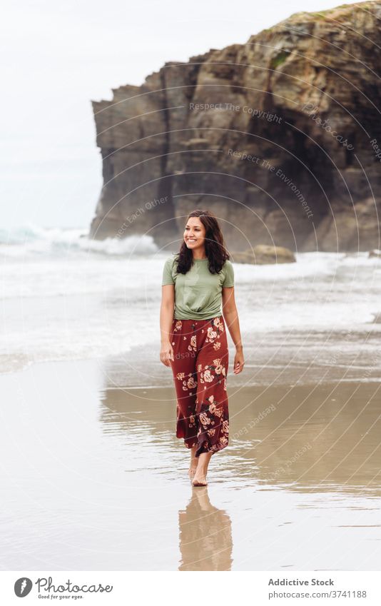 Lächelnde Frau am Strand im Sommer nass Meeresufer Spaziergang MEER Wasser Klippe Seeküste sich[Akk] entspannen reisen Tourismus Reisender Küste felsig Felsen