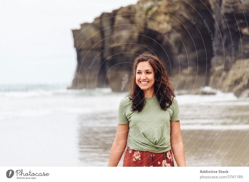 Lächelnde Frau am Strand im Sommer nass Meeresufer Spaziergang MEER Wasser Klippe Seeküste sich[Akk] entspannen reisen Tourismus Reisender Küste felsig Felsen