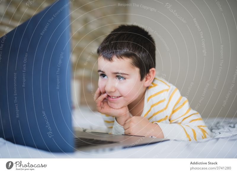 Kleines Kind verwendet Laptop zu Hause benutzend heimwärts wenig Apparatur Junge Browsen Schlafzimmer Surfen Internet Süchtige Gerät online Lifestyle männlich