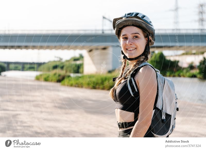 Porträt einer schlanken jungen Frau in Sportkleidung, die in die Kamera schaut Radfahrer sportlich Aktivität ruhen Schutzhelm Übung Flasche Biker Pause Durst