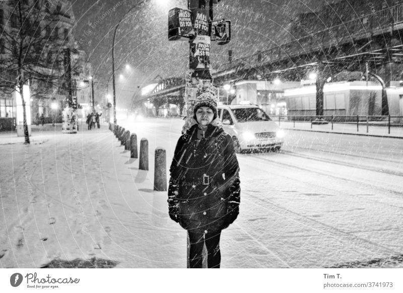 eine Frau steht bei Schneefall Nachts an einer Ampel Winter Berlin Prenzlauer Berg Schönhauser Allee bnw Stadtzentrum Hauptstadt Außenaufnahme Altstadt