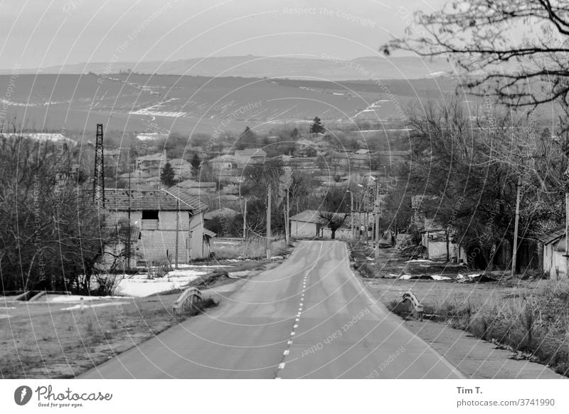 eine Straße in Bulgarien s/w Schwarzweißfoto b&w b/w ruhig Einsamkeit Dorf Landschaft Januar Verkehr Allee Fahrt Autofahrt
