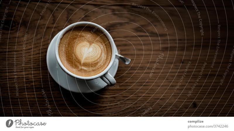 Cappuccino Love Liebe herzform aufschäumen zweig heissgetränk mitnehmen zum becher kreation kaffee cafe schaum muster milchschaum holztisch to go take away