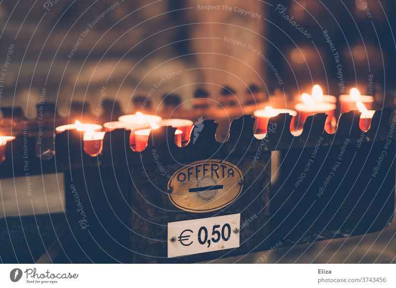 Brennende Opferkerzen, die gegen eine Spende von 50 Cent in einer italienischen Kirche angezündet werden Kerzen kosten 50cent 50 cent Geld Gedenken Trauer