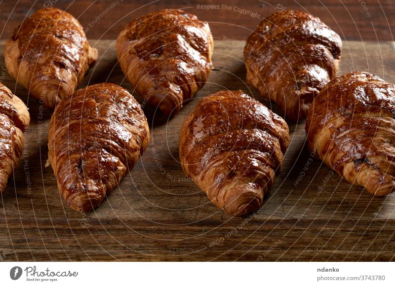 gebackene Croissants auf einem braunen Holzbrett, köstliches und appetitliches Gebäck Kruste Küche lecker Dessert Teigwaren Lebensmittel Französisch frisch