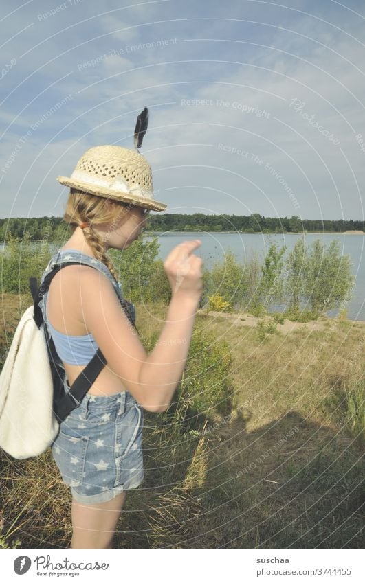 mädchen mit feder am hut an einem see See Deutschland Natur Ausflug wandern Sommer Strohhut Feder Rucksack Abenteuer Ferien & Urlaub & Reisen Freiheit