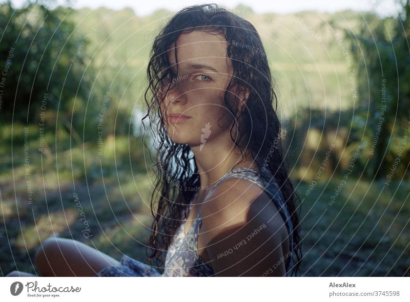 Analoges Portrait einer jungen Frau an einem Seeufer in der Natur mit Licht und Schatten durch Bäume schönes Wetter Stimmung selbstbewußt Kleid nasse haare