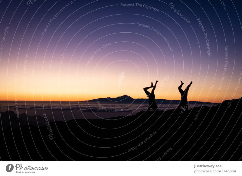 Silhouette von zwei Handständen mit dem Sonnenuntergang Himmel Gran Canaria Menschen Natur Berge u. Gebirge Landschaft orange Abenddämmerung Person Wolken Hügel