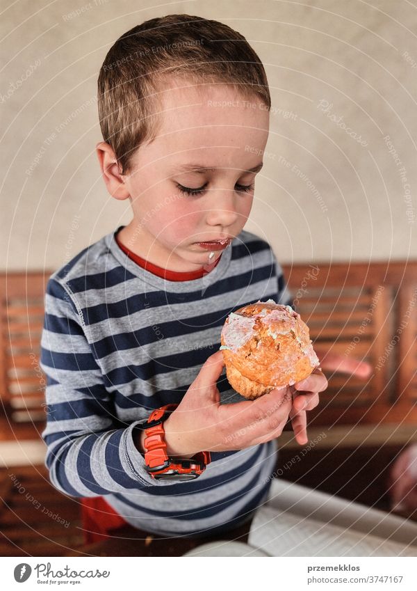 Junge genießt den süßen leckeren Muffin, den Sie selbst gebacken haben Kind Essen Cupcake Keks Dessert Glück essen Fröhlichkeit heiter klein wenig ungesund