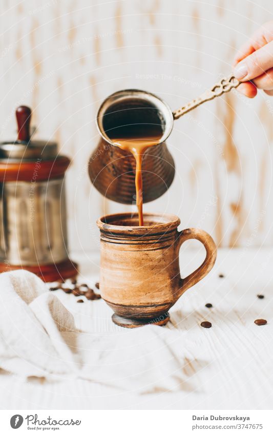 Kaffee in die Tasse giessen, Bohnen auf Holzuntergrund Aroma Frühstück hölzern Hintergrund Café Morgen trinken braun schwarz dunkel Getränk Koffein heiß frisch