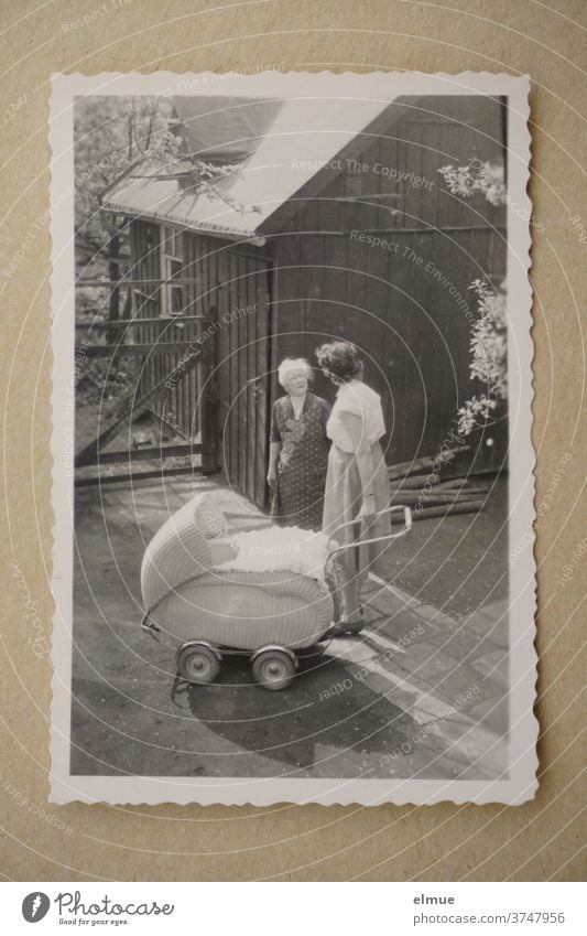 Erinnerungen an die 1960er Jahre - schwarz-weiß Bild mit Büttenrand zeigt drei Generationen in einem Vorgarten / modischer Kinderwagen und Mutter mit Großmutter im Gespräch