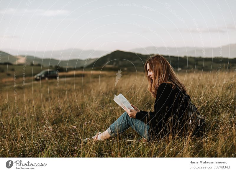 Junge schöne blonde Frau mit blonden Haaren Alleinreisende liest ein Buch in der Natur allein weg von der Stadt Schönheit Konzept Landschaft