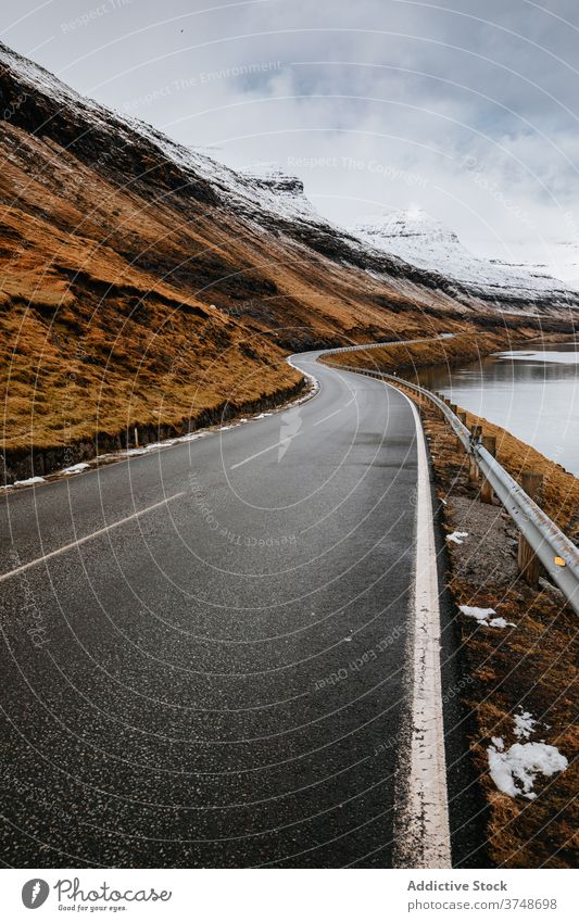 Nasse Bergstraße auf den Färöer Inseln Berge u. Gebirge Straße Winter nass geschlängelt spektakulär Fahrbahn Berghang Fluss kalt Färöer-Inseln Landschaft Felsen