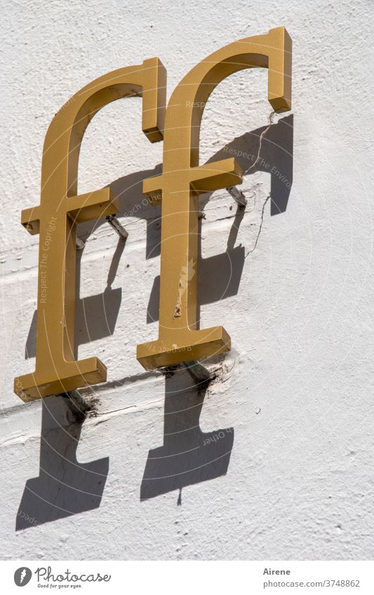 effeff Buchstabe Buchstaben F FF Gold golden Schatten Schrift Inschrift Überschrift kursiv schräg Relief Hauswand Shop Laden Ladenfront Druckschrift Serife