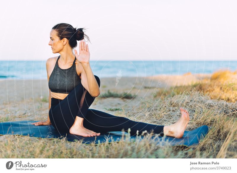 junge Frau, die Yoga-Übungen auf dem Boden im Freien am Meer macht Menschen Gesunder Lebensstil Gleichgewicht trainiert. Lebensstile eine Person Sonnenlicht
