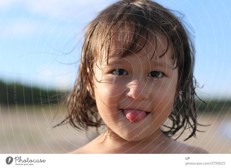 kleines Mädchen, das seine Zunge herausstreckt Blick in die Kamera Oberkörper Porträt Sonnenuntergang Sonnenaufgang Sonnenstrahlen Sonnenlicht Licht