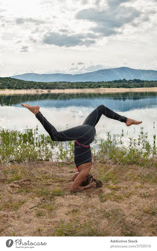 Frau übt Kopfstand Yoga-Pose in der Nähe von See üben sirsasana Asana Gleichgewicht Umkehrung Variation fortgeschritten Harmonie Wellness Lifestyle beweglich