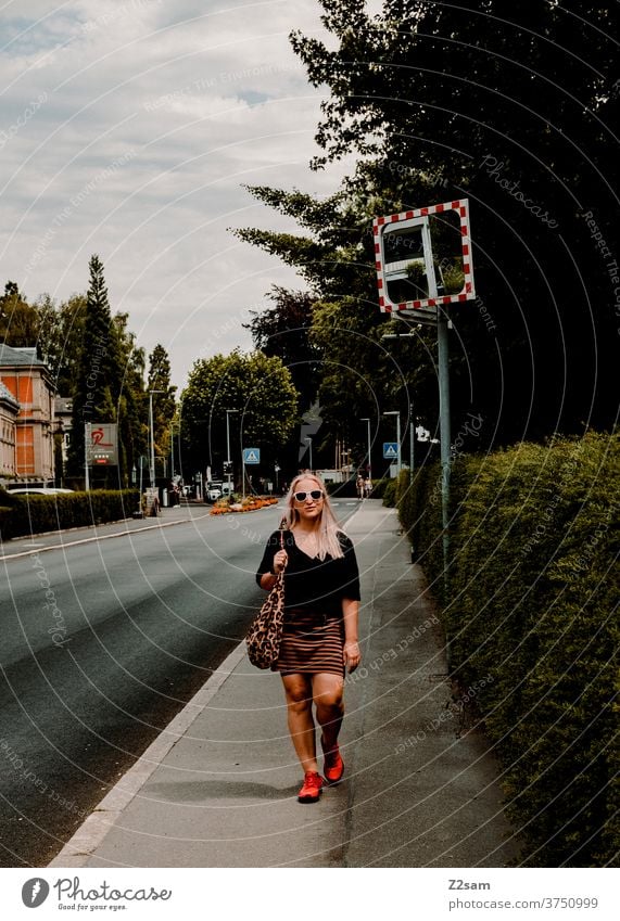 Junge Frau schlendert durch die Straßen von Überlingen am Bodensee junge frau blond lange haare schlendern straße grün stadt überlingen himmel wolken sommer