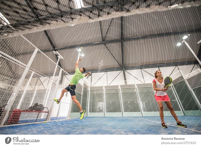 Paddle-Tennis-Training in der Halle. Weitwinkelansicht unter dem Netz Paddeltennis Padel Sport Erholung Klasse Gericht Mann Frau Frauen Männer blau Lebensstile
