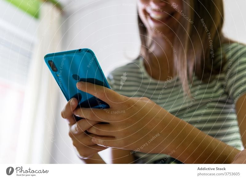 Crop Frau Chatten auf Smartphone zu Hause lesen Nachricht soziale Netzwerke Talkrunde unterhalten Wochenende benutzend Funktelefon heimwärts Surfen online