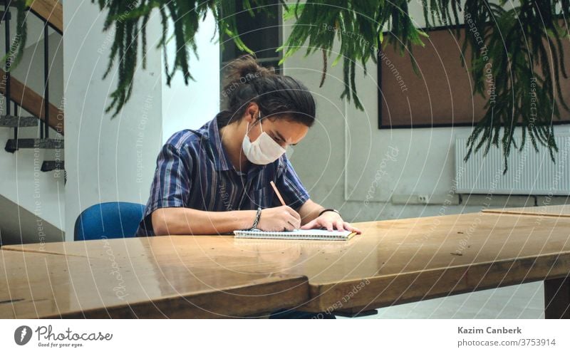 Isolierte, maskierte College-Studentin, die allein in der Bibliothek mit schönem Sonnenlicht studiert Korona Hintergrund weiß vereinzelt Gesundheit Wissenschaft