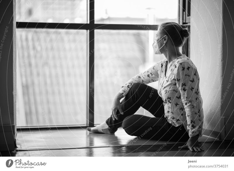 Frau mit FFP2 Maske blickt einsam und isoliert aus dem Fenster | Corona Pandemie | corona thoughts Coronavirus Corona-Pandemie Schutzmaske Mundschutz Prävention