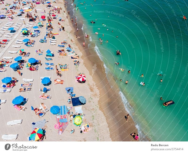 Luftaufnahme von Menschen und bunten Regenschirmen am Strand des Ozeans im Sommer Antenne Ansicht Sand Hintergrund Wasser MEER Urlaub blau reisen mediterran