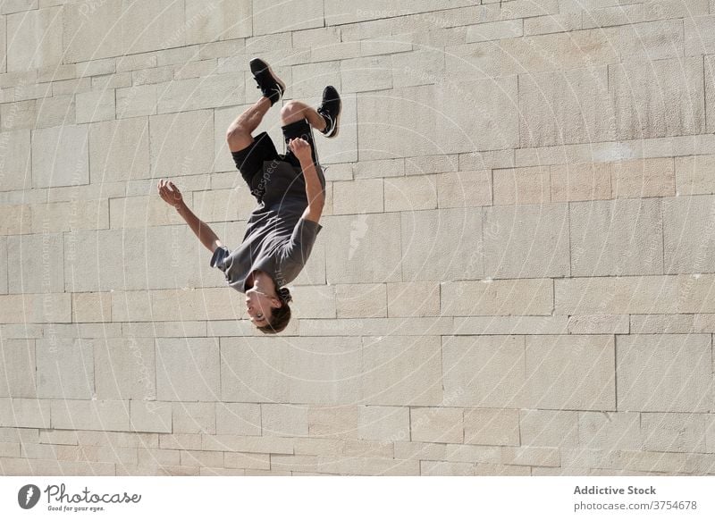 Mann macht Rückwärtssalto in der Stadt Le Parkour Überschlag springen akrobatisch Stunt Trick urban aktiv männlich Energie Sommer üben Übung