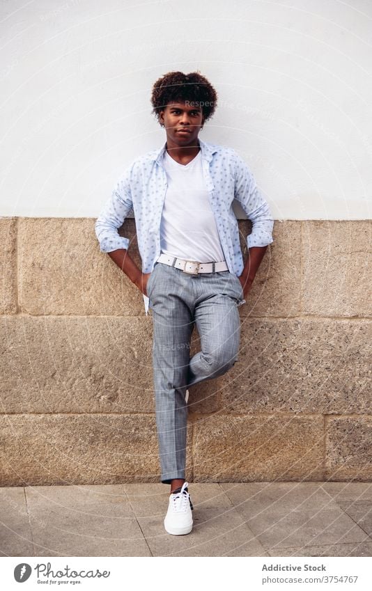 Selbstbewusster Mann in stilvoller Kleidung in der Stadt Stil trendy modern Großstadt Straße Körperhaltung emotionslos Gebäude Wand männlich ethnisch schwarz