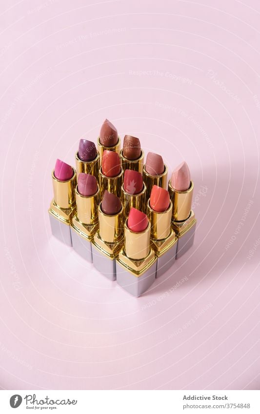 Satz von bunten Lippenstiften auf rosa Hintergrund Sammlung Make-up Produkt Ordnung Reihe Kulisse Farbe matt Schönheit professionell sortiert Linie dekorativ