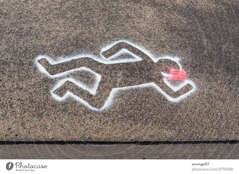 Tatort Straße | mit weißer Sprühfarbe auf schwarzem Asphalt markierte Umrisse einer auf der Straße liegenden Person schwarzer Asphalt Weiße Farbe umrissen