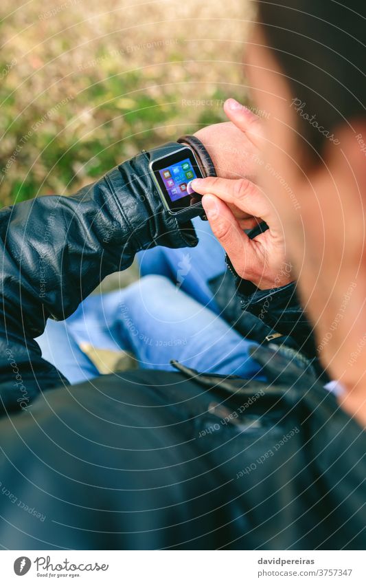Unbekannter junger Mann benutzt seine Smartwatch unkenntlich Hand smartwatch berührend zuschauen Zeigen tragbar Technik & Technologie Blick Mitteilung