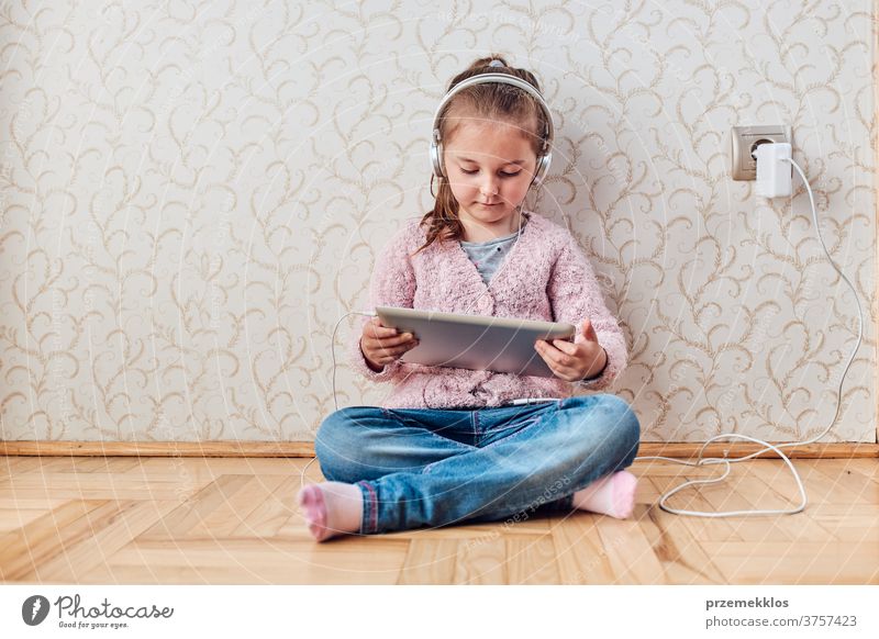 Kleines Mädchen im Vorschulalter lernt online Rätsel lösen und spielt zu Hause Lernspiele auf Tablet Aufmerksamkeit Bett Schlafzimmer Kaukasier Kind Kindheit