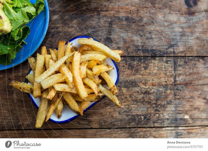 Pommes Frites mit Avocado und Senfsalat Fries Französisch Kartoffel Chips Salatbeilage Blätter Lebensmittel gelb Snack schnell braten hölzern golden essen