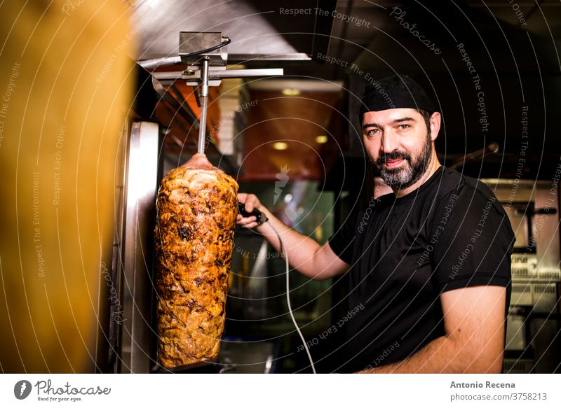 Bärtiger Mann, der in einer Pizzeria Kebab-Fleisch zubereitet. Türkisch Erwachsener Person Menschen Lifestyle attraktiv Männer männlich bärtig Verkäufer Laden