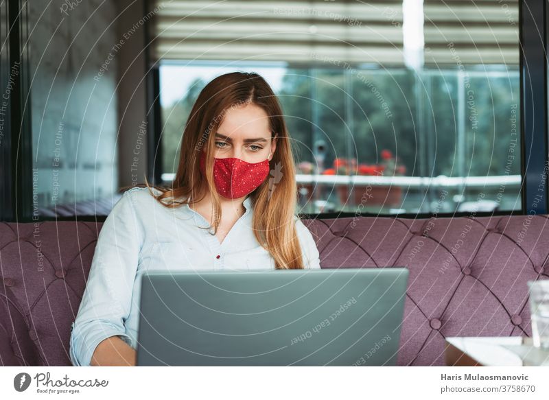 Freiberuflerin mit Gesichtsmaske arbeitet am Laptop im Café Erwachsener attraktiv schön Business Geschäftsfrau Kaffee Kaffeehaus Mitteilung Coronavirus