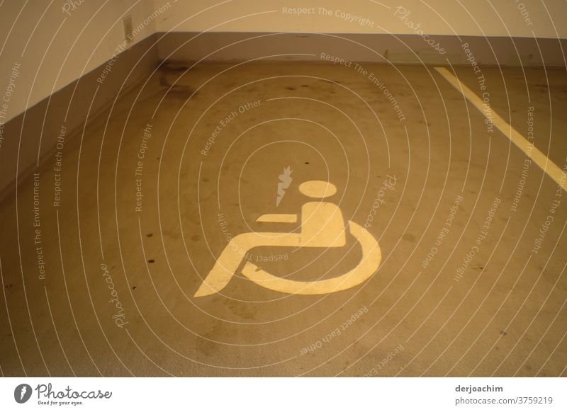 Reserviert für Behinderte ist der  Parkplatz in der Tiefgarage. Mit einem auf dem Boden gezeichnetem   liegendem Rollstuhl Bild. Garageneinfahrt Parkhaus parken