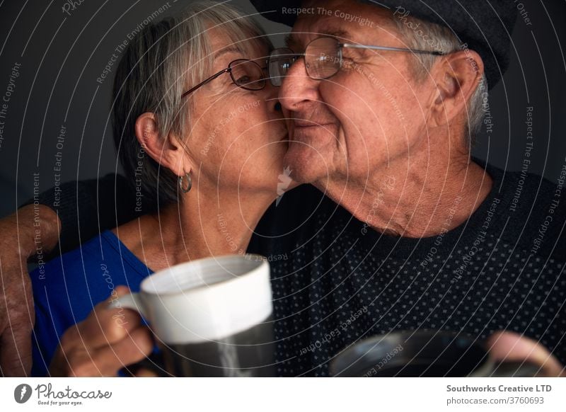 Glückliches älteres Paar, das sich küsst und lacht Senior Küssen Lächeln Lachen 70 70's Kuss Hipster Reife grauhaarig ältere Menschen Babyboomer liebevoll