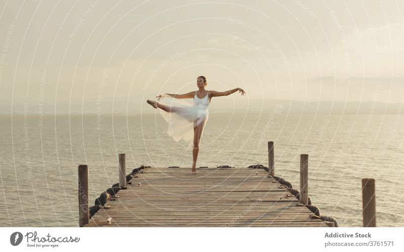 Schlanke Ballerina tanzt auf Strandpromenade in der Nähe von Meer Anmut Tanzen MEER Promenade beweglich klassisch Balletttänzer elegant Pose Sonnenuntergang