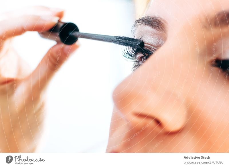 Crop-Visagist trägt Mascara auf Modell auf Wimperntusche Make-up Künstler bewerben Gesicht professionell Schönheit Produkt Verfahren Bürste Klient vorbereiten