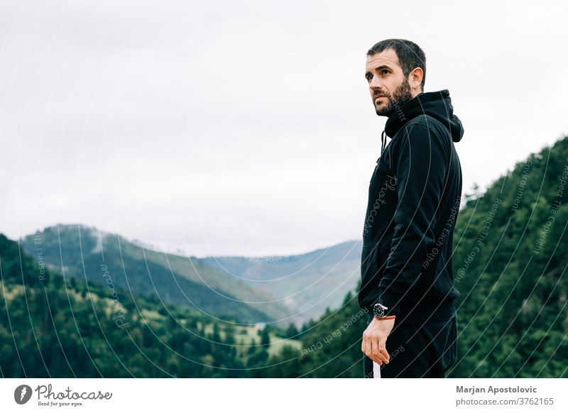 Junger männlicher Naturforscher geniesst die Aussicht auf op des Berges Erwachsener Abenteuer allein bärtig lässig Kaukasier wolkig Landschaft Morgendämmerung