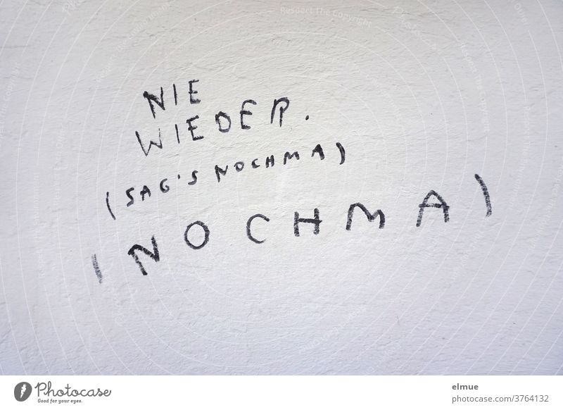 "NIE WIEDER (SAG's NOCHMA) (NOCHMA)" steht in Druckbuchstaben mit schwarz geschrieben an der grauen  Wand nie wieder Schmiererei Wiederholung Wortklauberei