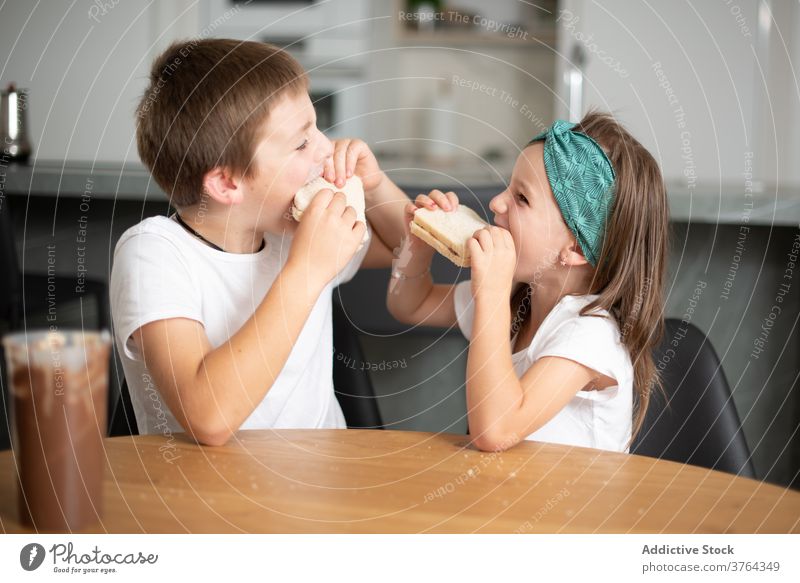 Geschwister essen Schokoladenbrot Mädchen Junge aufgeregt Kind erstaunt Kinder Essen heiter Lebensmittel optimistisch positiv Frühstück Mund Spaß Frau süß Glück