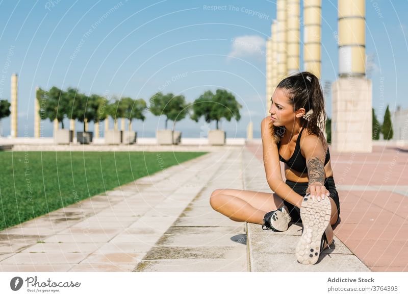 Weibliche Läuferin bindet die Schnürsenkel vor dem Training auf der Straße Sportlerin Krawatte Schuhbänder Turnschuh Übung urban Athlet passen Frau vorbereiten