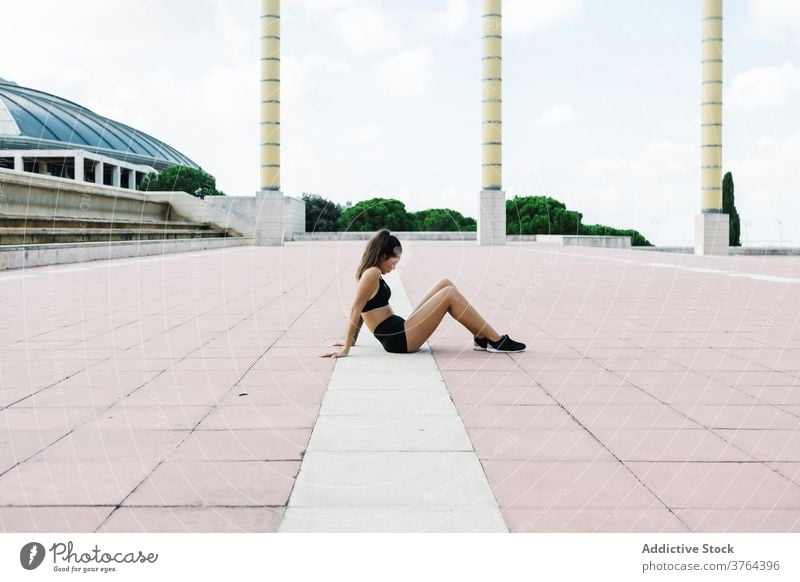 Fitte Frau in Sportkleidung ruht sich nach dem Training auf dem Stadtplatz aus passen ruhen sich[Akk] entspannen Straße Pause Fitness urban Erholung müde Übung