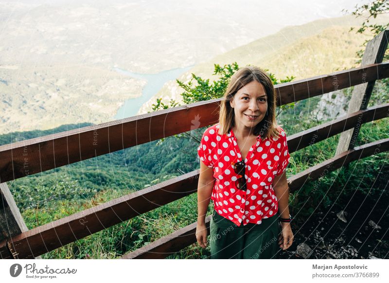 Junge Naturforscherin geniesst die Aussicht vom Aussichtspunkt in den Bergen See Erwachsener Abenteuer allein Hintergrund schön lässig Kaukasier Ausflugsziel