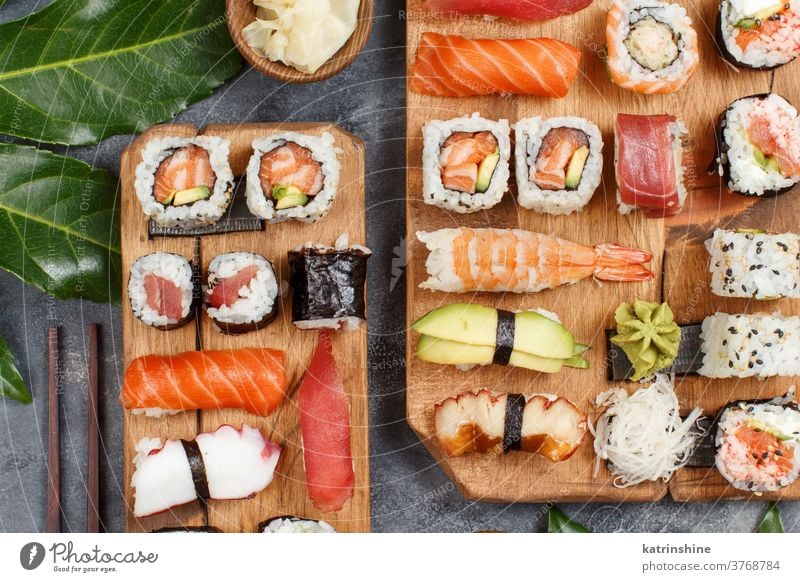 Sushi Set Nigiri und Sushi-Rollen auf rechteckigen Holzplatten verzehrfertig Essen Sashimi Brötchen maki Sushi-Bar Esszimmer Japanische Kultur Meeresfrüchte