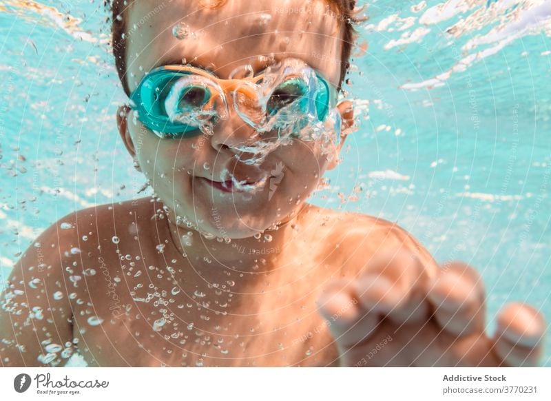 Glückliches Kind im Schwimmbad Junge schwimmen Pool Sommer Spaß haben Schutzbrille Sauberkeit Wasser Wochenende positiv Kindheit sich[Akk] entspannen Resort